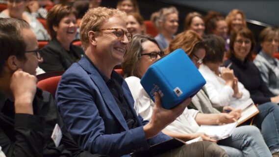 man die lacht met een box in zijn hand